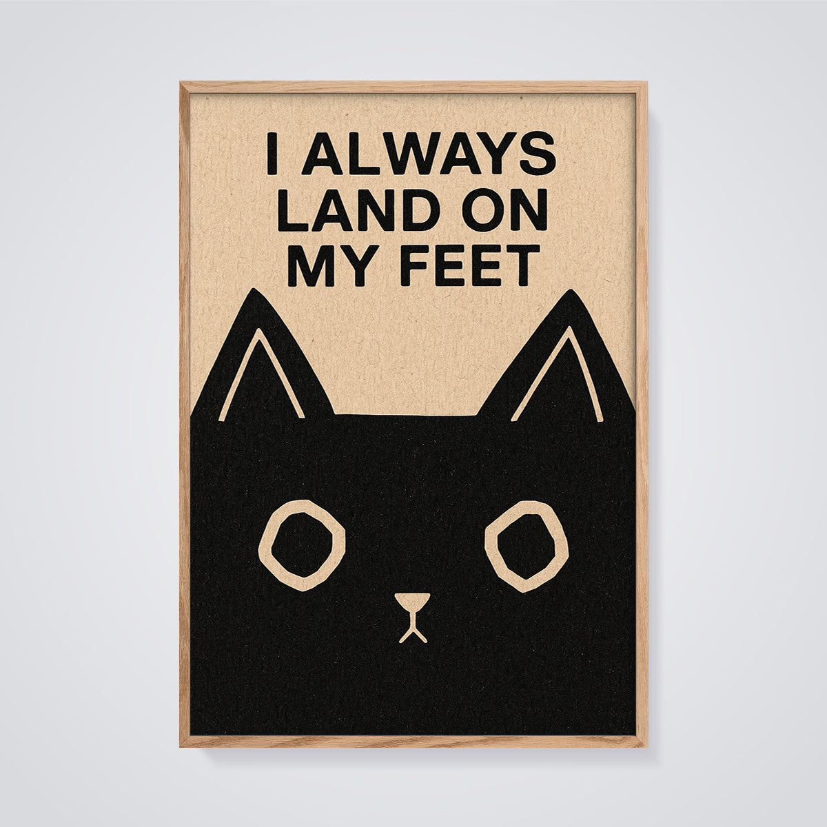 I Always Land on My Feet Cat Print framed in oak on a grey background