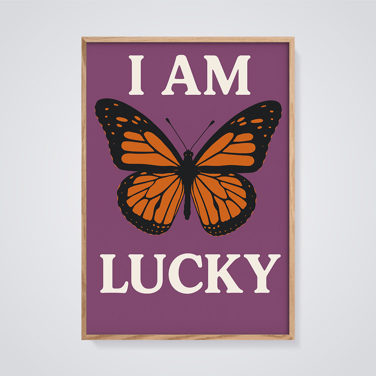 I Am Lucky Monarch Butterfly Print framed in oak on a grey background
