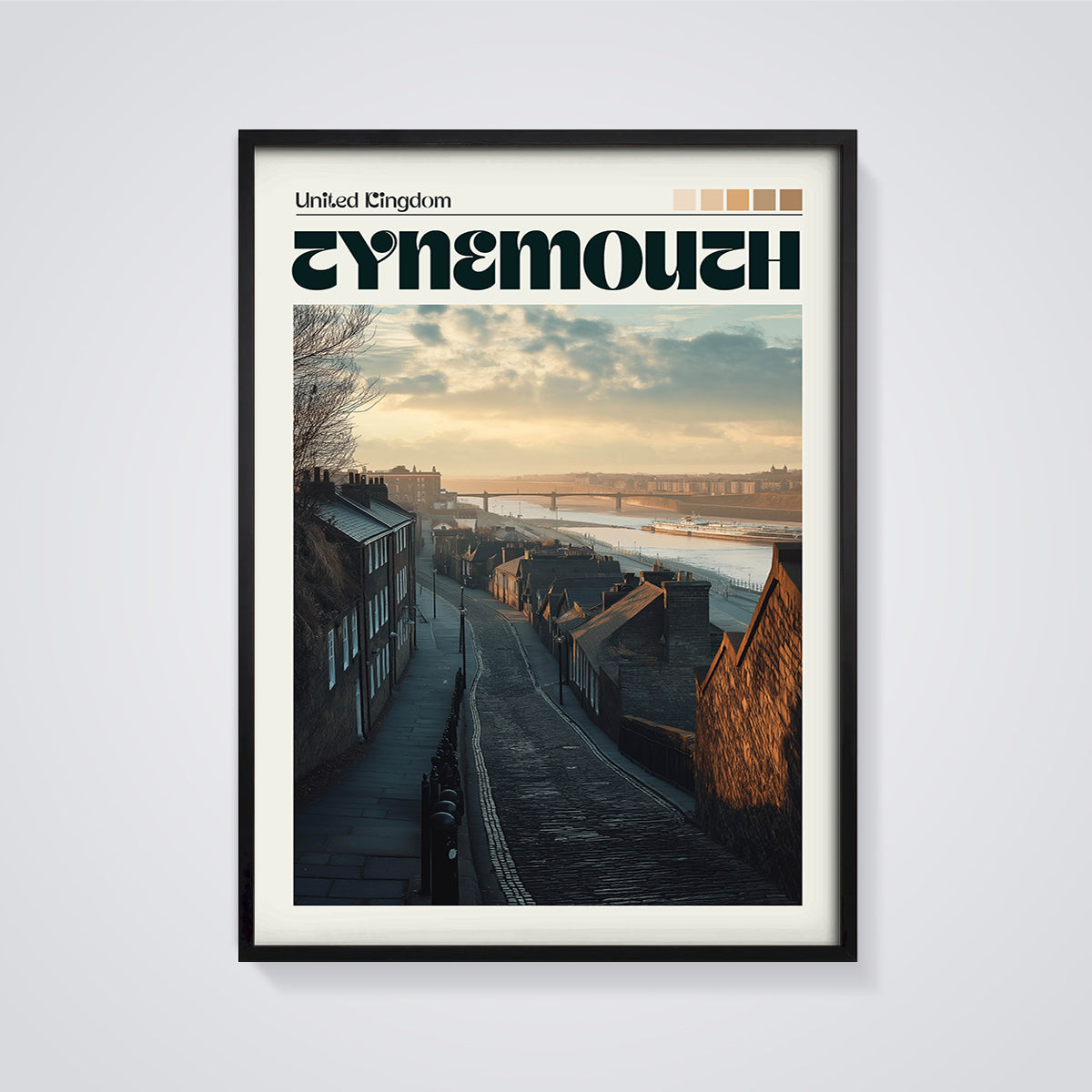 Tynemouth Cobblestone Street Print framed in black on a grey background